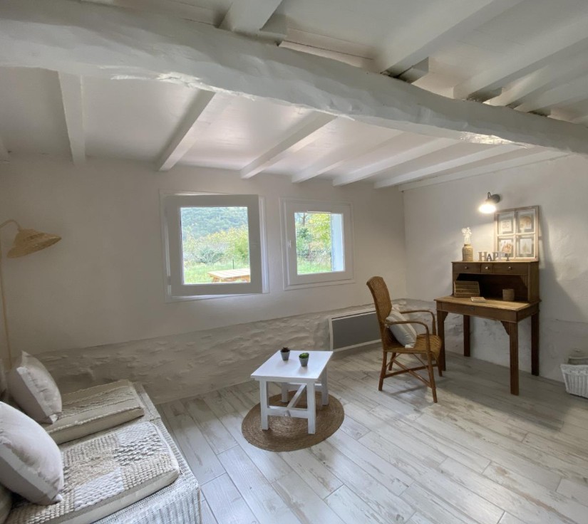 Pièce détente avec bureau et fauteuil en rotin
