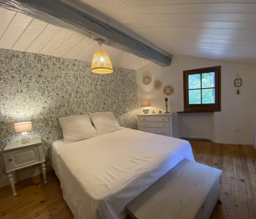 Chambre double avec papier peint floral vert et lit en 140