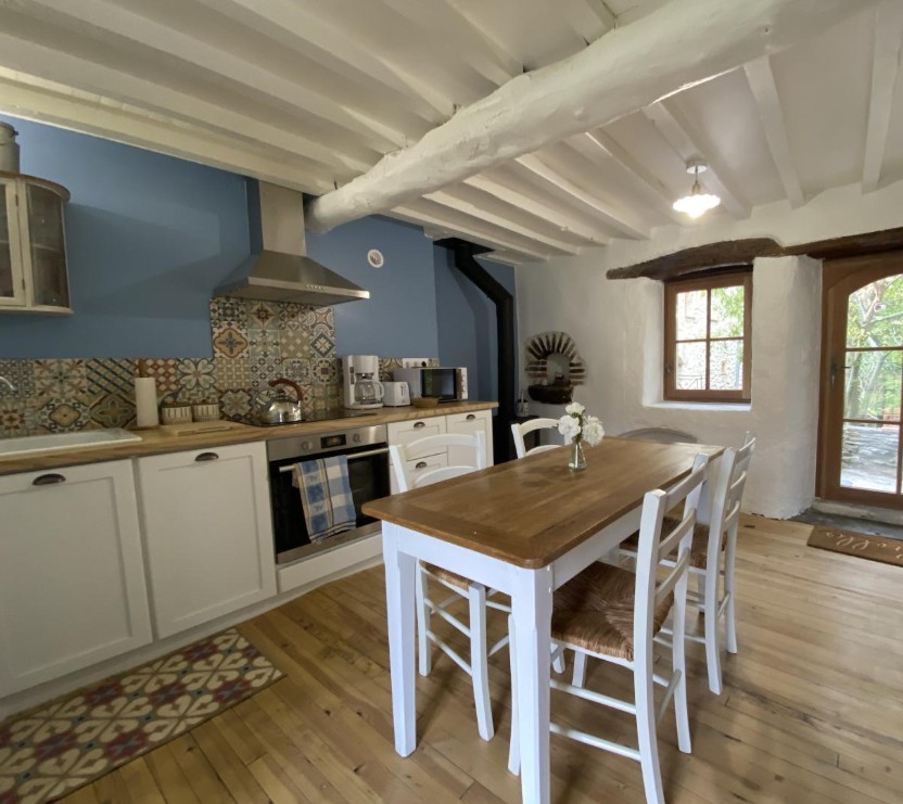 Cuisine équipée bleue avec carreaux de ciment et table en bois