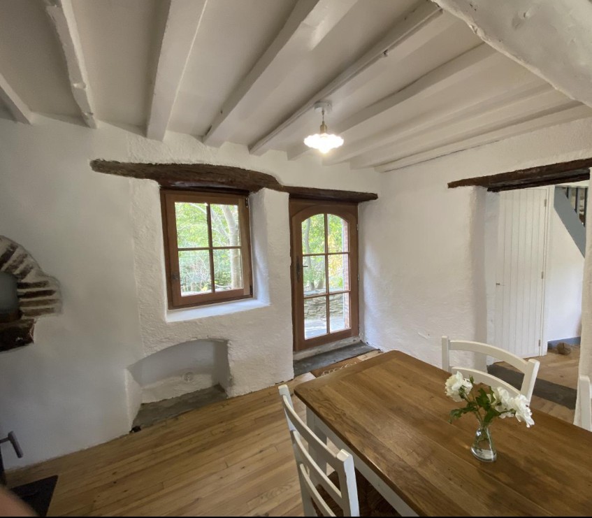 Salle à manger avec porte voûtée et table en bois